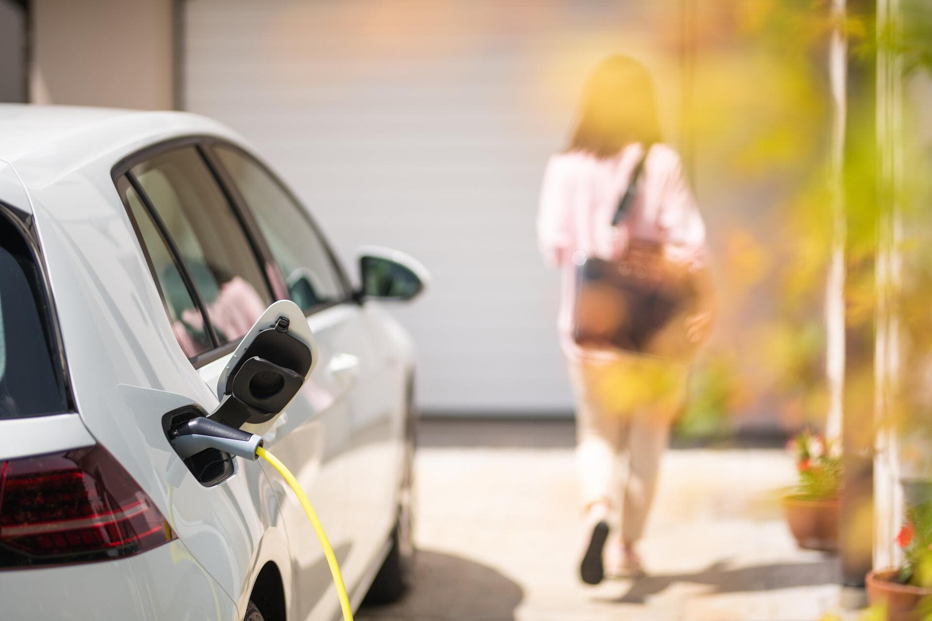 EV plugged in and charging in a driveway